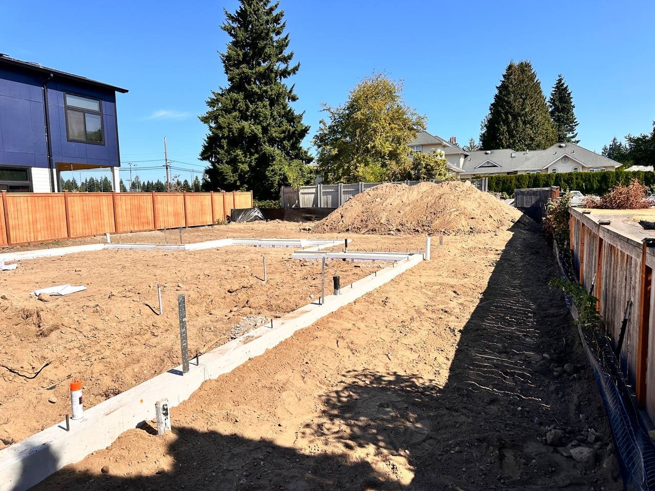 L-shaped ADU concrete foundation in residential backyard by Artbrick