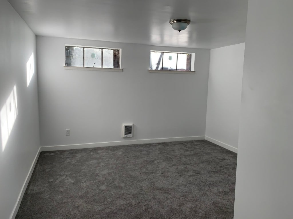 Basement bedroom with twin egress windows and new carpet by Artbrick
