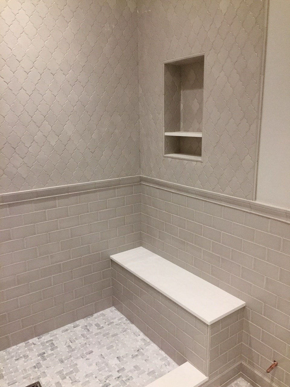 Walk-in shower with arabesque tile and built-in bench by Artbrick