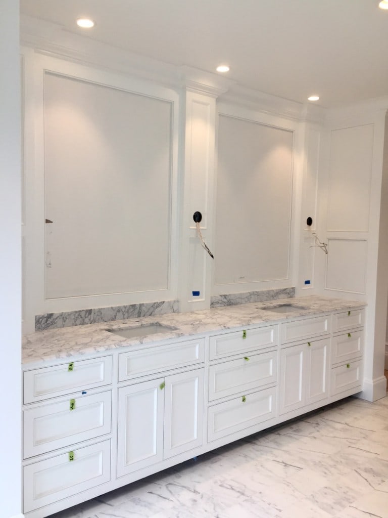 White double vanity with Carrara marble countertop and recessed-panel cabinetry by Artbrick