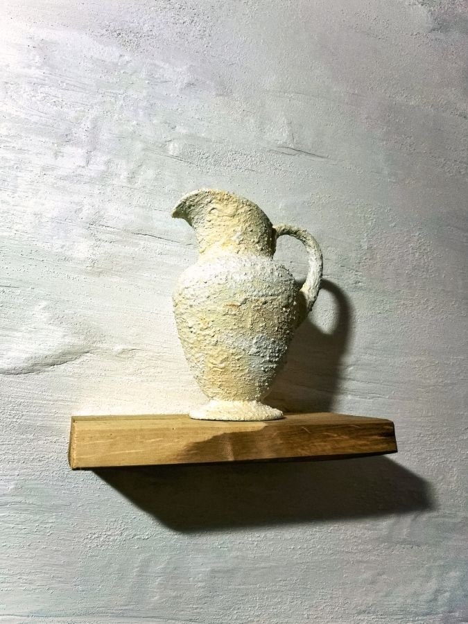 Hand-sculpted textured decorative plaster pitcher on a wood shelf by Artbrick