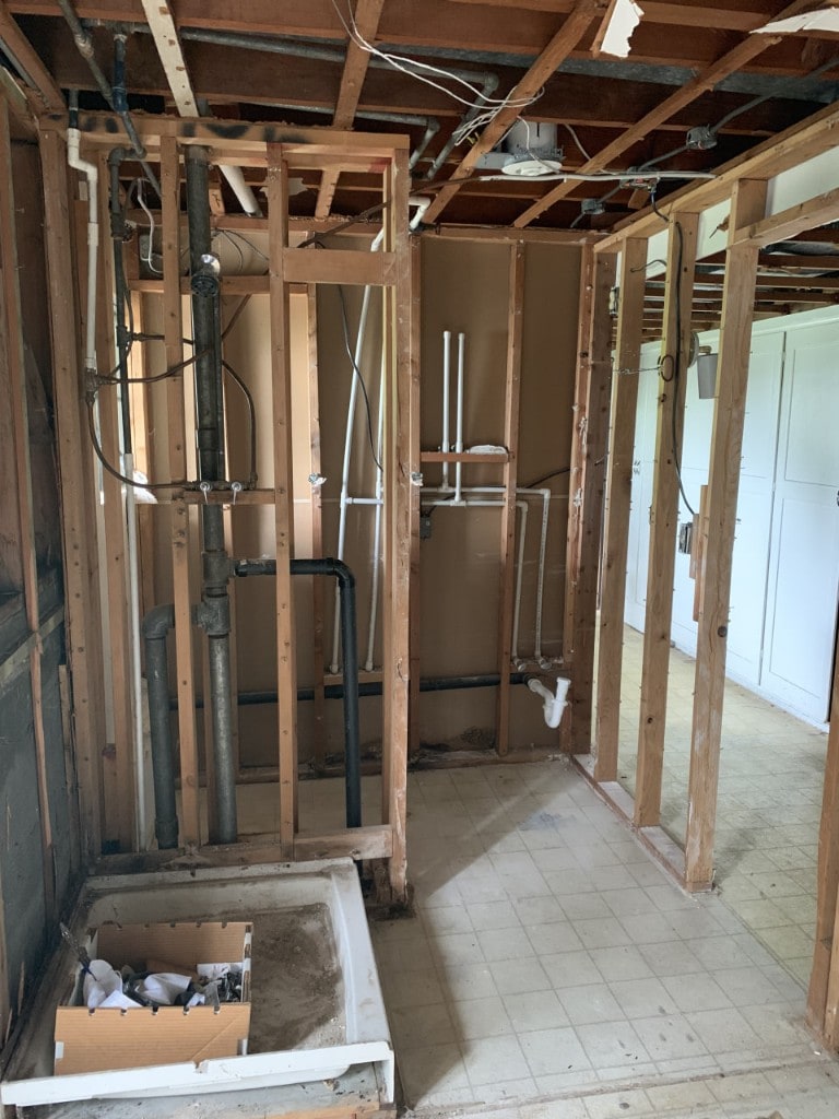 Bathroom stripped to framing with plumbing stack and rough-in exposed by Artbrick