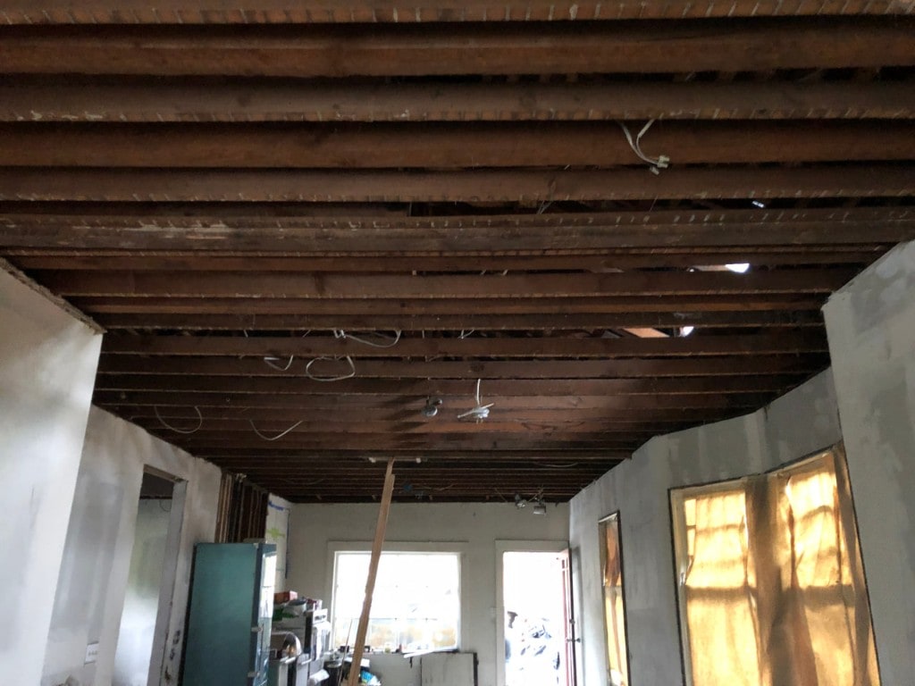 Ceiling stripped to exposed joists during interior demolition by Artbrick