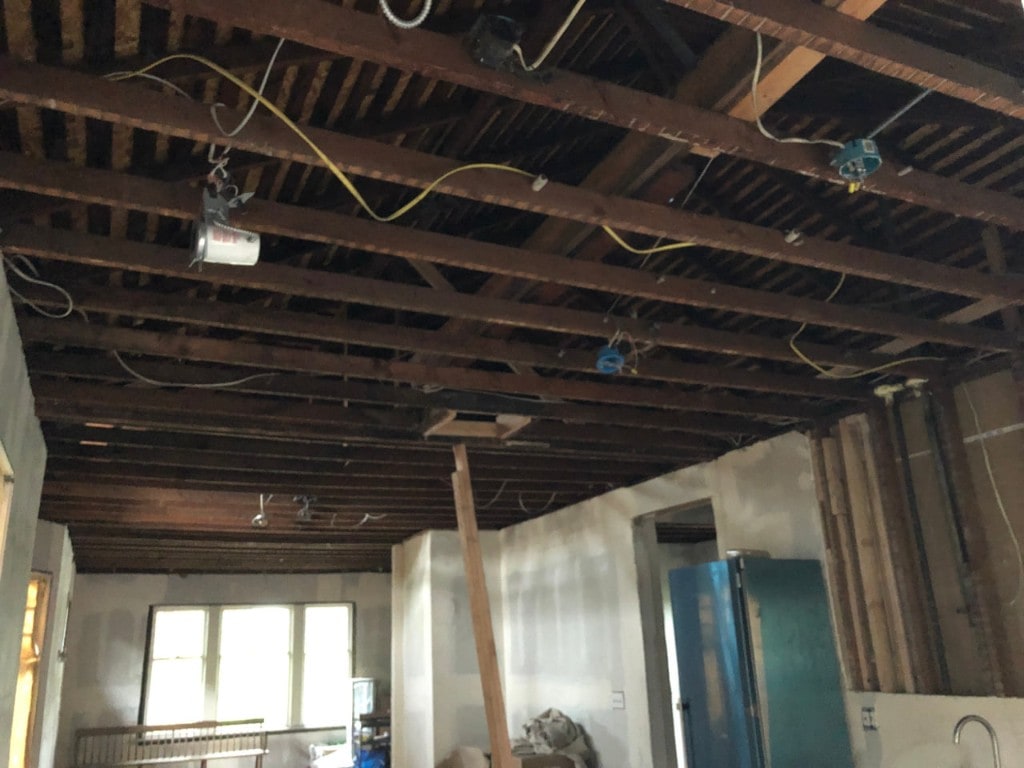 Exposed ceiling joists and wiring after demolition by Artbrick