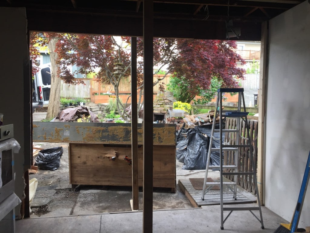 Exterior wall opened to the backyard with temporary shoring post during demolition by Artbrick