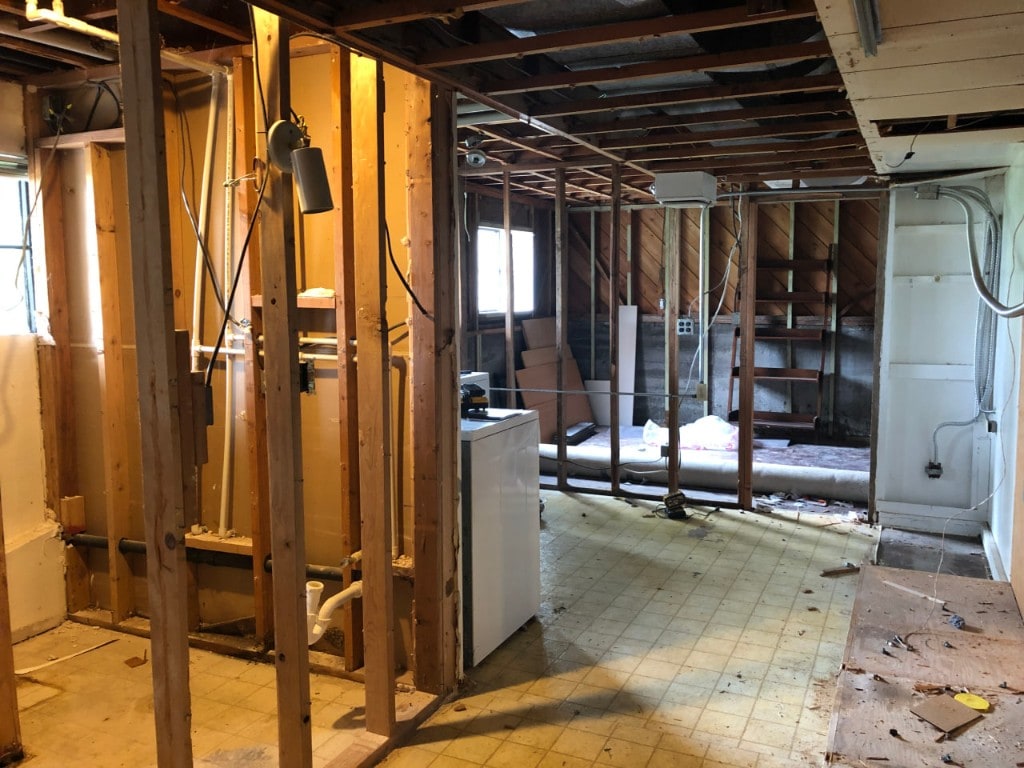 Open framing and laundry area during a whole-room interior demolition by Artbrick