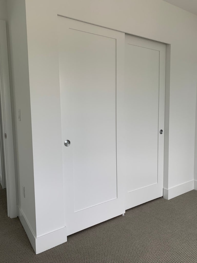 Bright room with freshly painted walls and white sliding closet doors by Artbrick