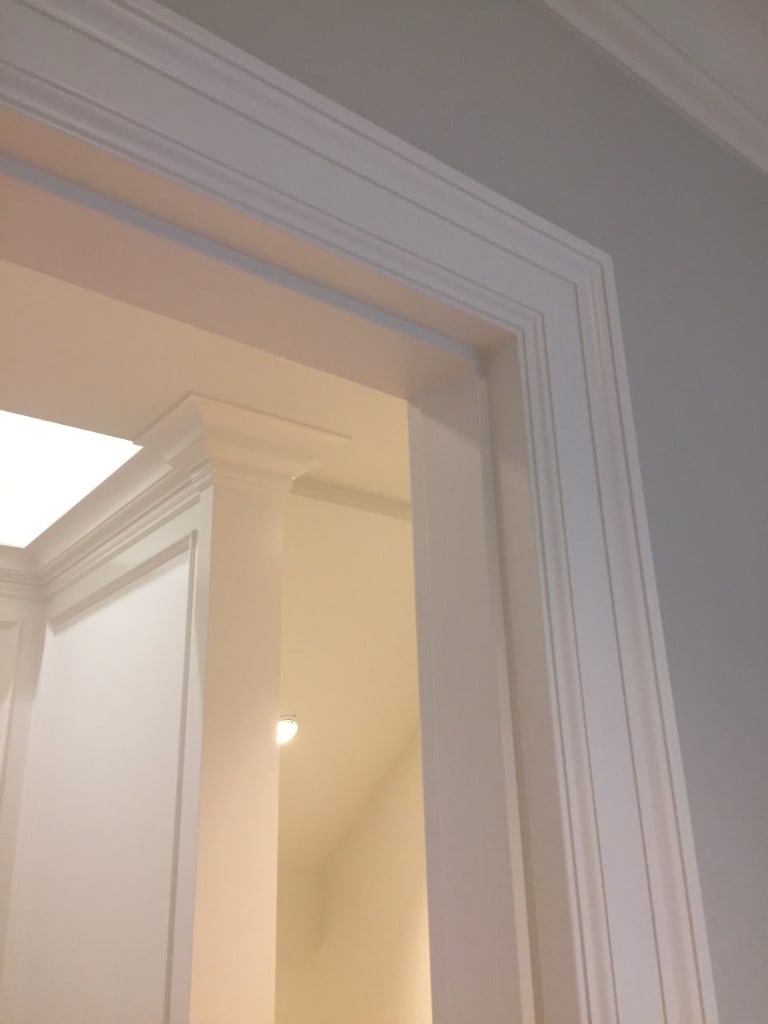 Painted crown molding and door trim corner with clean lines by Artbrick