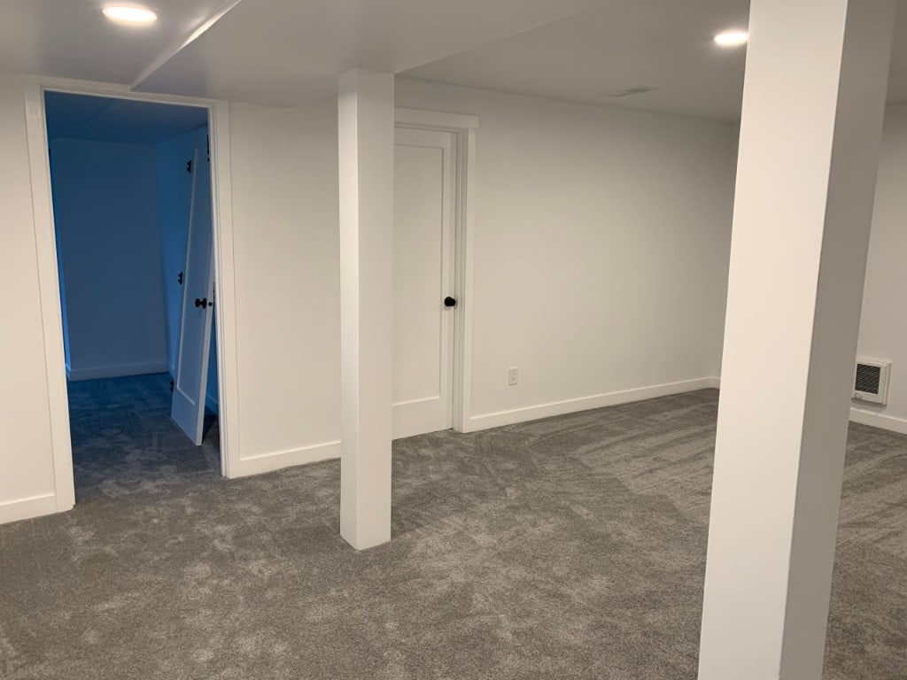 Repainted finished basement with white columns, doors, and trim by Artbrick