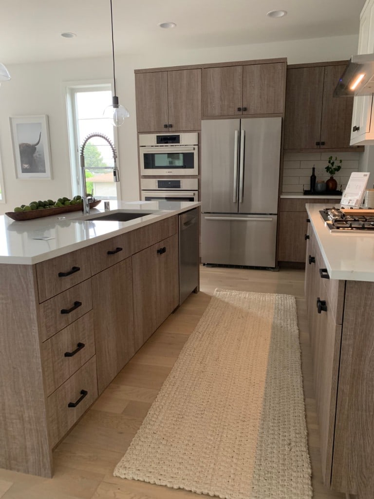 Kitchen remodel with wood-grain cabinets, a quartz island, and stainless appliances by Artbrick