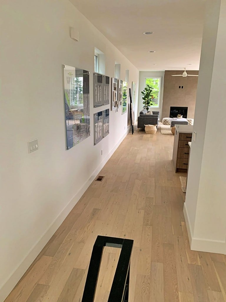 Whole-home renovation hallway opening to a finished living room with hardwood floors by Artbrick