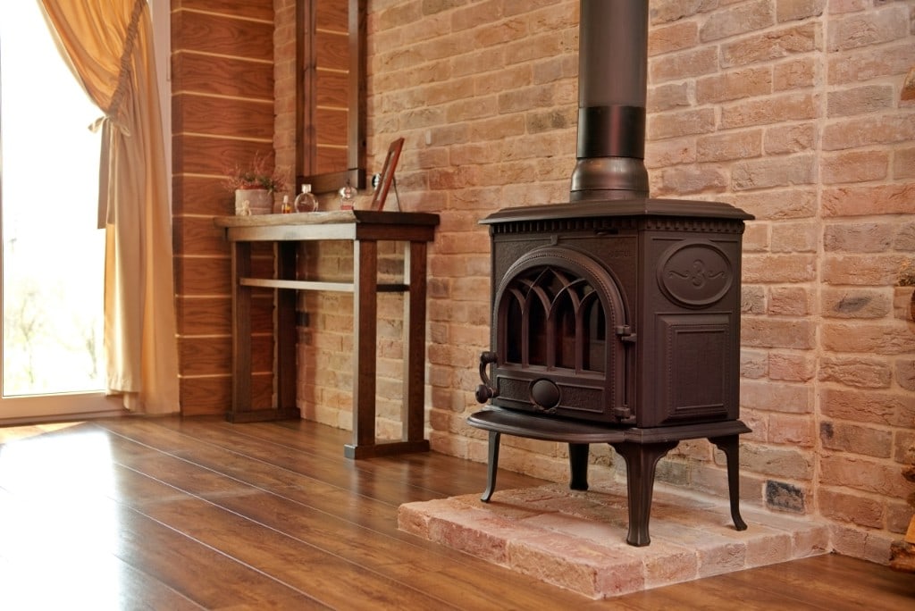 Brick feature wall with a cast-iron wood stove in a whole-home renovation by Artbrick